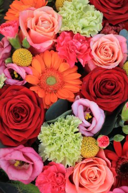 Karışık çiçek aranjmanı: kırmızı, pembe ve turuncunun farklı tonlarında çeşitli çiçekler