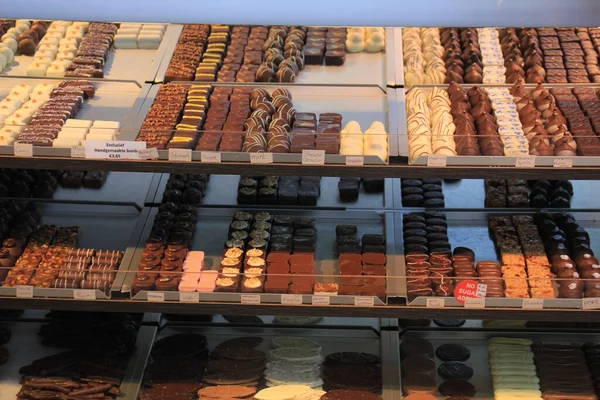 お菓子屋さんのディスプレイ上の豪華なチョコレート オランダ語で価格と製品情報 — ストック写真