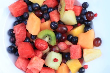 Parlak renklerde taze meyve salatası, taze nane yapraklarıyla süslenmiş.