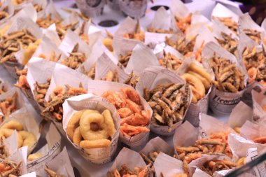 Barselona, İspanya - 30 Eylül 2019: La Boqueria Market 'te kızarmış balık. Çeşitli deniz ürünleri, balık kroket ve mürekkep balığı halkaları.