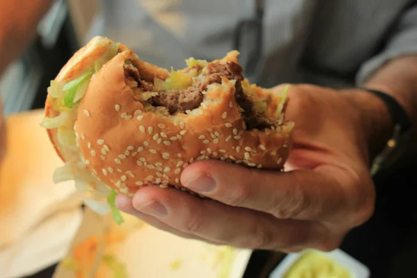 Mann Hält Einen Frisch Gemachten Hamburger Der Hand lizenzfreie Stockbilder