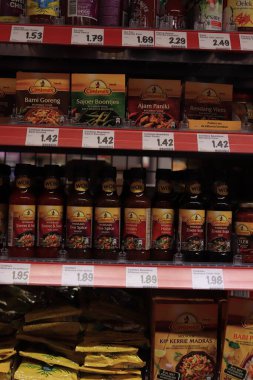 Haarlem, Hollanda - 31 Temmuz 2021: Bir süpermarkette Conimiex sosları ve baharatları. Conimex, Endonezya ürünlerinde uzmanlaşmış bir Hollanda markasıdır. Etiketler üzerine metin: Hollanda 'da ürün bilgileri, Euro cinsinden fiyatlar.