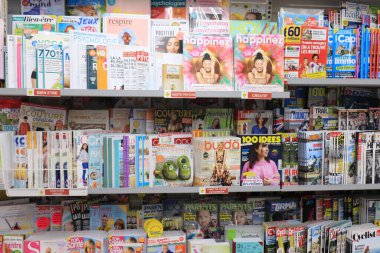 Autun, Fransa - 17 Eylül 2021: Bir Fransız süpermarketinde büfede dergiler. Konuya göre sıralanır