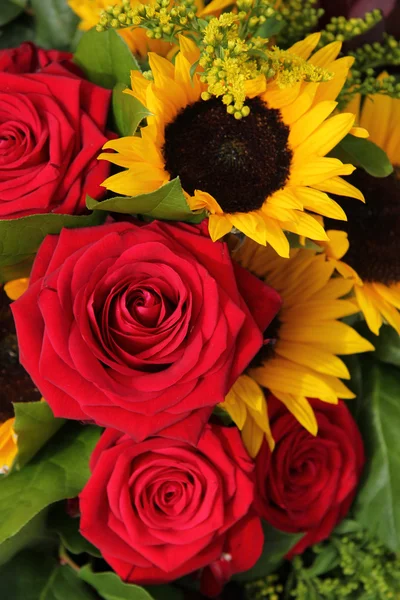 Rote Rosen und Sonnenblumen in einem Blumenarrangement — Stockfoto