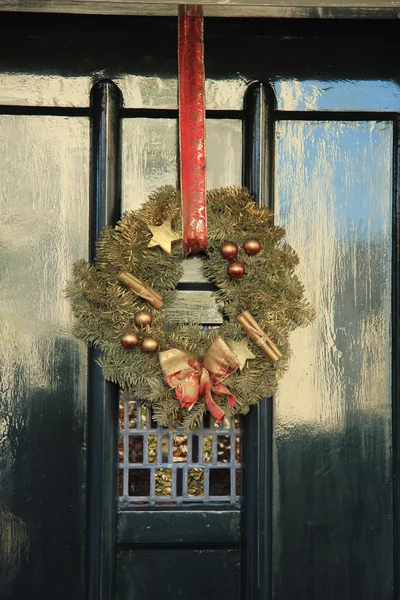 Classic christmas wreath with decorations on a door — Stock fotografie