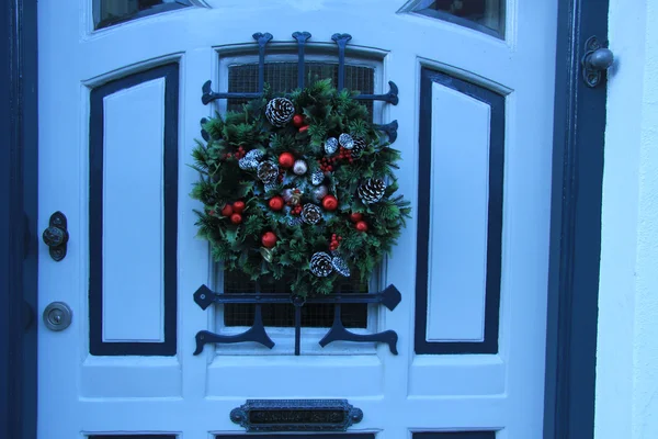 Classic christmas wreath with decorations on a door — Stock Photo, Image