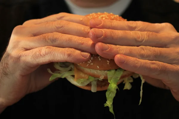 Man holding a hamburger — Stock Photo, Image