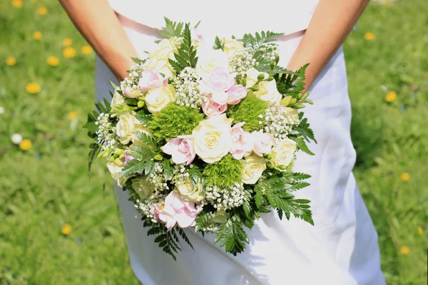 Braut hält Blumenstrauß — Stockfoto