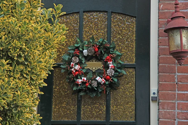 Christmas wreath with decorations on a door — Stock Photo, Image