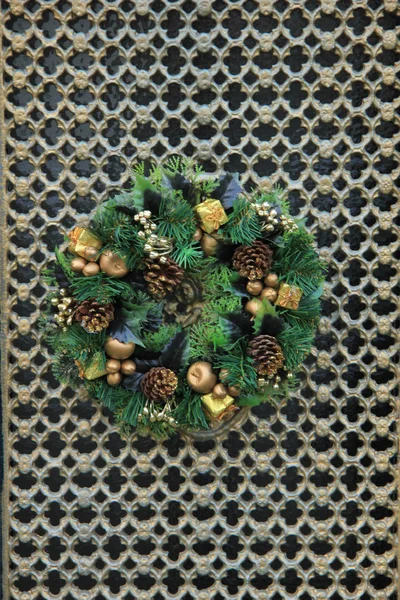 Classic christmas wreath with decorations on a door — Stock fotografie