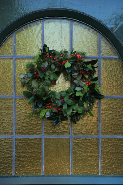 Classica corona di Natale con decorazioni su una porta — Foto Stock