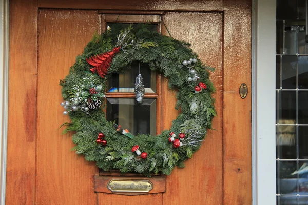 Grinalda de Natal clássica com decorações em uma porta — Fotografia de Stock