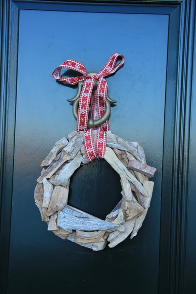 Clásica corona de Navidad con decoraciones en una puerta — Foto de Stock