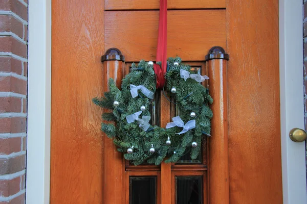 Классический рождественский венок с украшениями на двери — стоковое фото