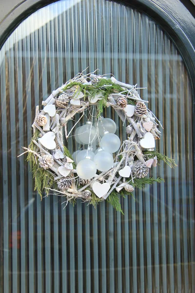 Corona de Navidad con decoraciones en una puerta — Foto de Stock