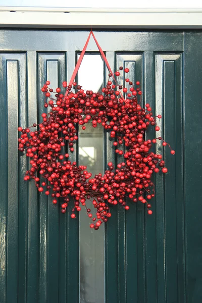 Berry Noel çelenk ile bir kapı süsleri — Stok fotoğraf