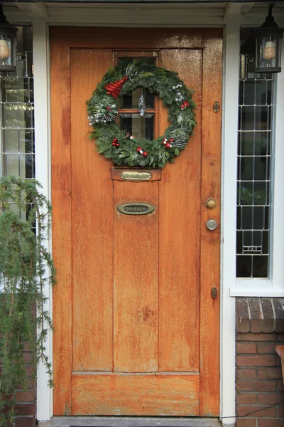 Classica corona di Natale con decorazioni su una porta — Foto Stock