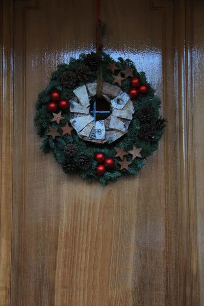 Corona de Navidad con decoraciones en una puerta — Foto de Stock