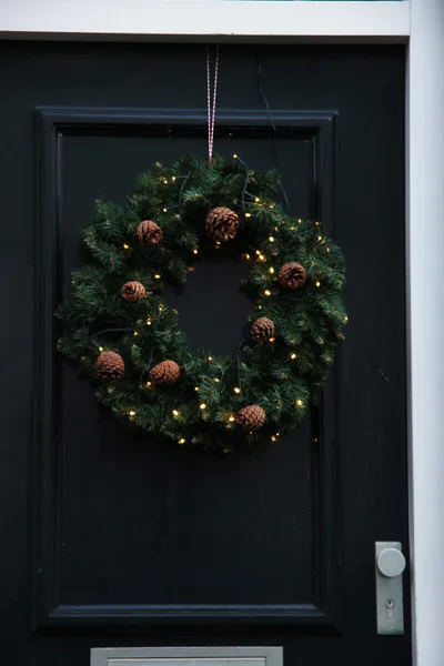 Classica corona di Natale con decorazioni su una porta — Foto Stock