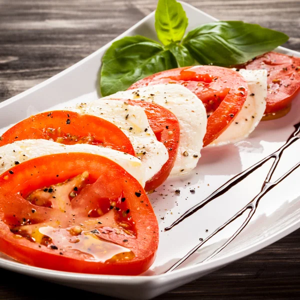 Салат из капрезе с сыром мозарелла, помидорами и базиликом — стоковое фото