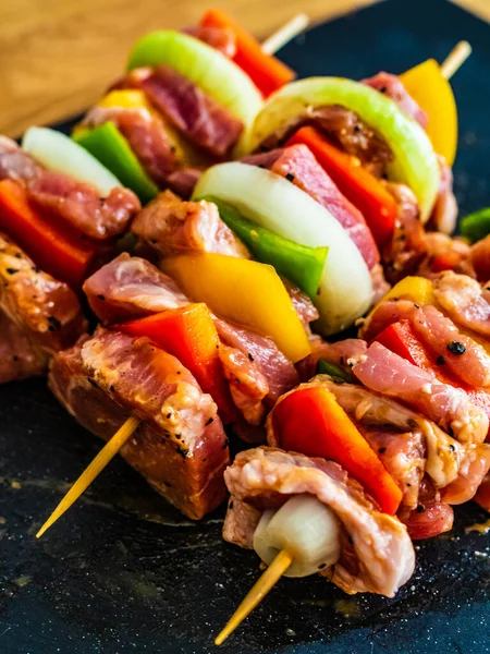 Rohes Schaschlik Und Gewürze Auf Schwarzem Steinbrett Auf Holztisch — Stockfoto