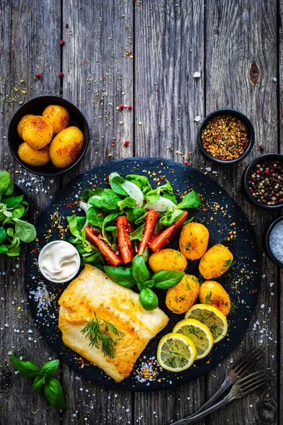 Visgerecht Gebakken Kabeljauwfilet Met Aardappelen Groentesalade Geserveerd Stenen Bord Houten — Stockfoto