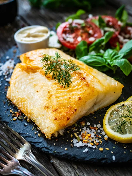 Fiskrätt Stekt Torskfilé Med Potatis Och Grönsakssallad Serverad Stenplatta Träbord — Stockfoto