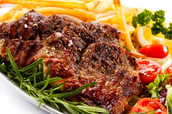 Grilled meat with French fries and vegetables — Stock Photo, Image