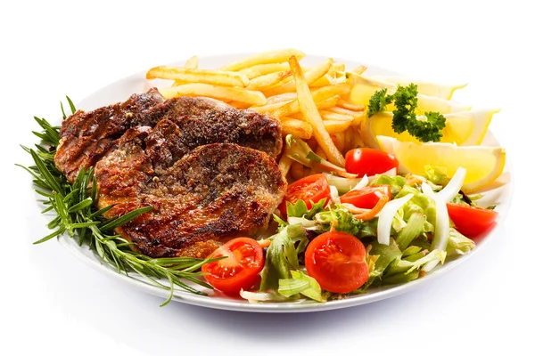 Grilled meat with French fries and vegetables — Stock Photo, Image
