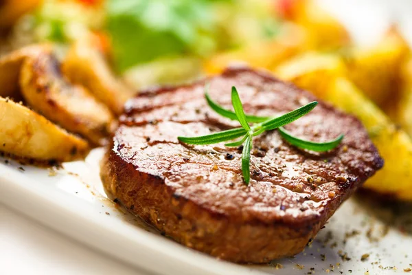 Steak grillé, pommes de terre au four et légumes — Photo