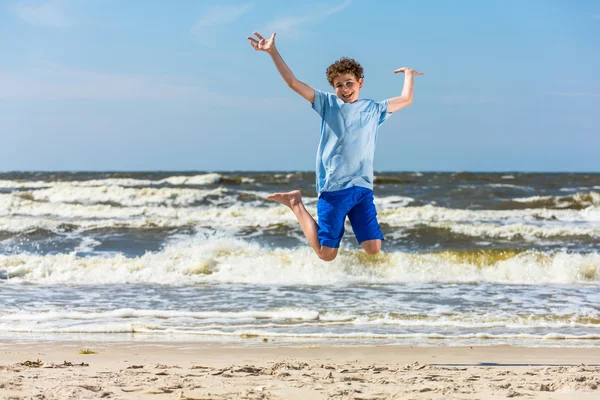 Niño saltando en la playa — Foto de Stock