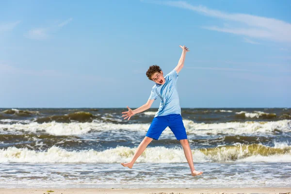 Chłopiec skacze na plaży — Zdjęcie stockowe