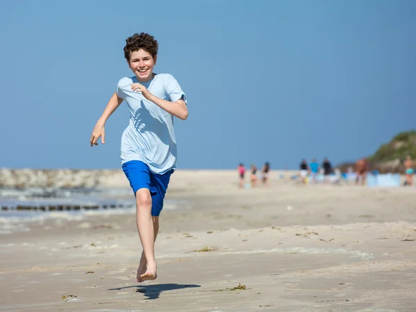 Pojke kör på stranden — Stockfoto