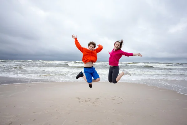 Girl and boy jumping together — Stock Photo, Image