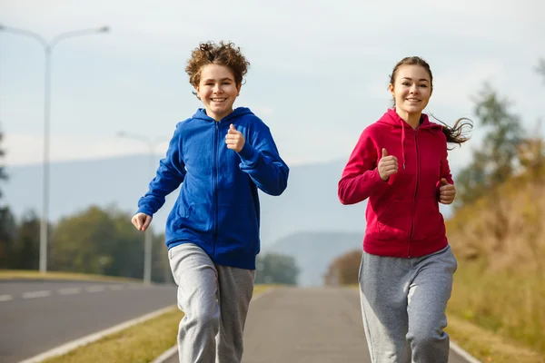Adolescente menina e menino correndo — Fotografia de Stock