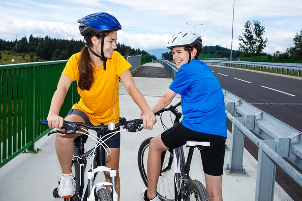 Tiener meisje en jongen paardrijden fietsen — Stockfoto