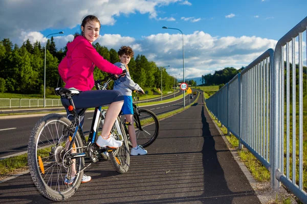 十几岁的女孩和男孩骑自行车 — 图库照片