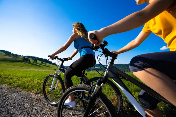 Två unga kvinnor cykling — Stockfoto