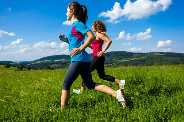 Mulheres correndo, pulando ao ar livre — Fotografia de Stock