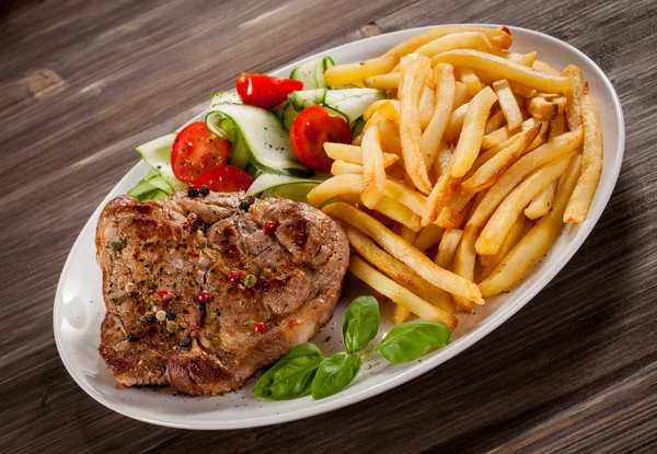 Grilled steak, French fries and vegetables — Stock Photo, Image