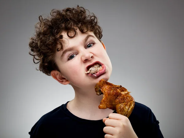 Menino comer frango — Fotografia de Stock