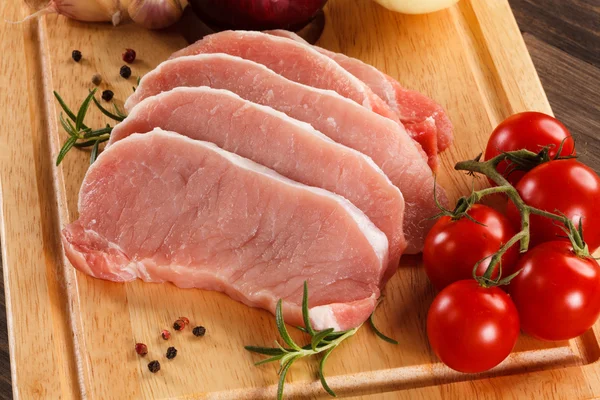 Frisches rohes Schweinefleisch auf Schneidebrett — Stockfoto