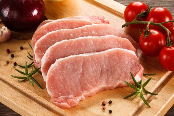 Frisches rohes Schweinefleisch auf Schneidebrett — Stockfoto