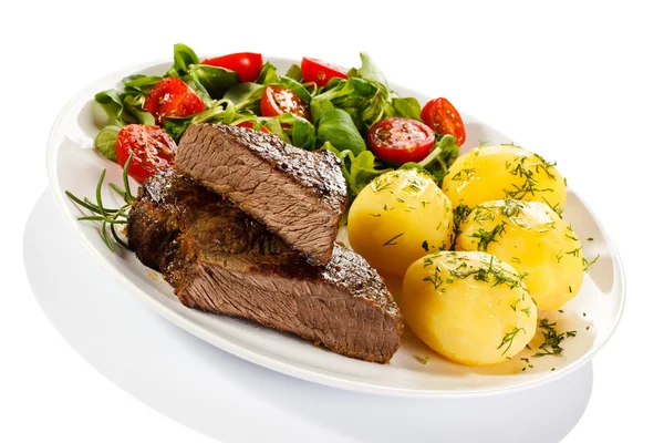 Grilled steaks, potatoes and vegetable salad — Stock Photo, Image