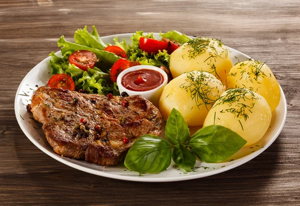 Grilled steaks, French fries and vegetables — Stock Photo, Image