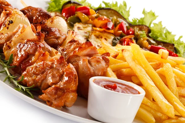 Grilled meat with French fries and vegetable salad — Stock Photo, Image