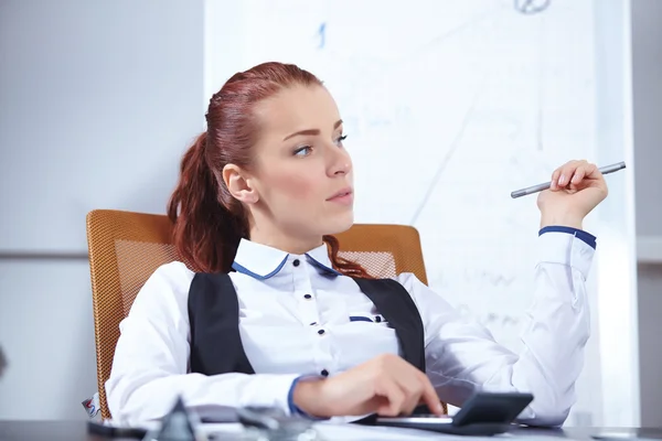 Geschäftsfrau sitzt am Arbeitsplatz — Stockfoto