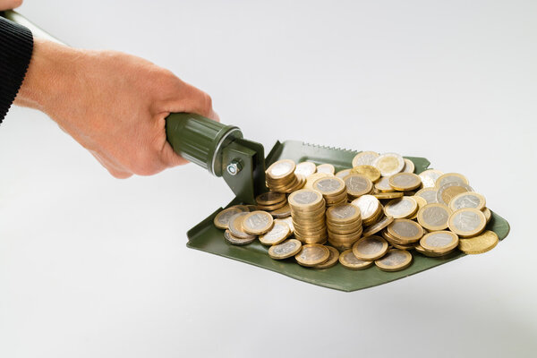 лопата с деньгами на белом
