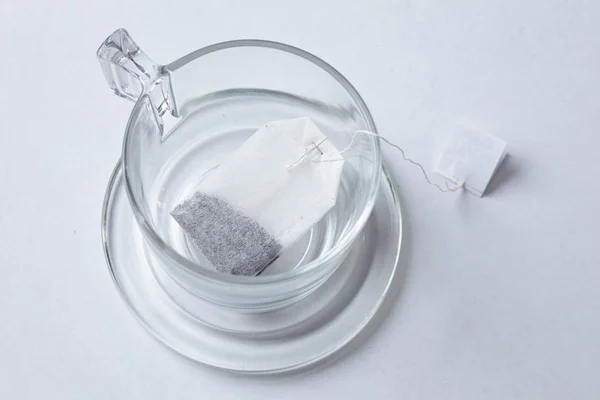 Closeup glass cup with teabag — Stock Photo, Image