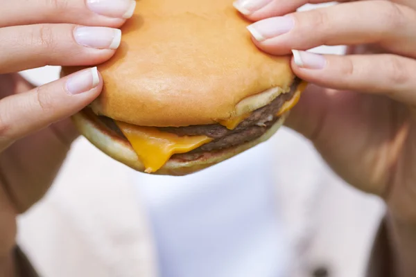 Žena jíst hamburger — Stock fotografie